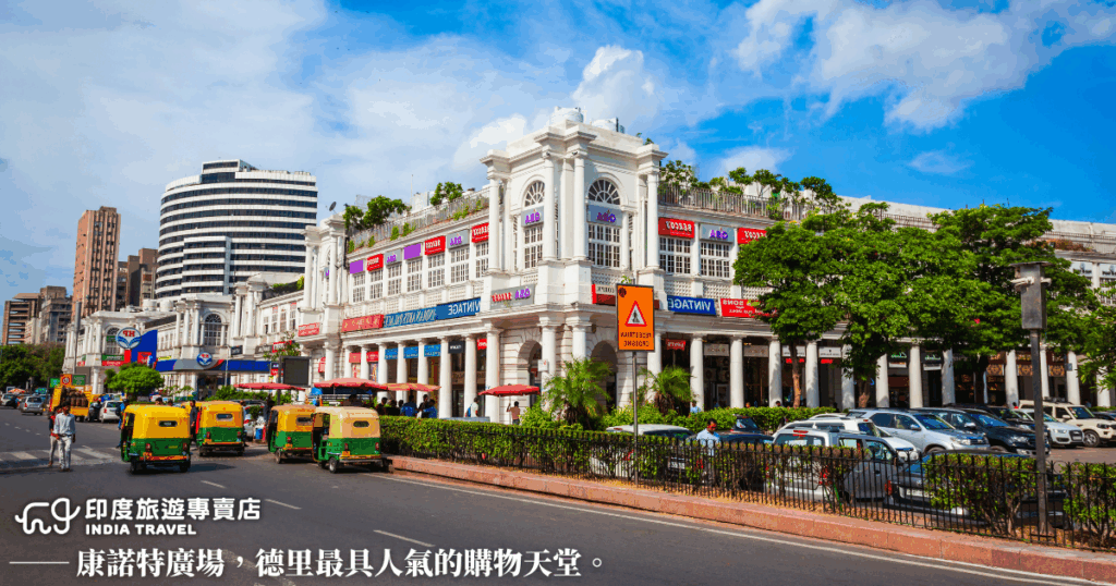 照片捕捉德里核心商業區康諾特廣場（Connaught Place）的街道景象，白色圓弧建築與英式柱廊構成殖民風格的典雅背景。街道兩旁有品牌店鋪與咖啡館，來往人群繁忙，是德里最具現代都市氛圍的地區。圖片呈現了舊時帝國與當代商業活力的交錯，非常適合用於城市導覽或旅遊生活風格文章。