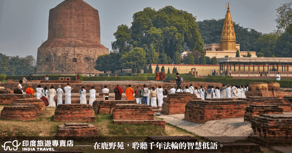 這張圖片拍攝於印度佛教四大聖地之一的鹿野苑(Sarnath),中央為達美克佛塔(Dhamek Stupa),前景可見身穿白衣與僧袍的朝聖者虔誠佇立、誦經祈禱。畫面帶有濃厚的宗教氛圍,象徵佛陀首次說法之地,適合作為印度佛教聖地相關文章、旅遊介紹或文化導覽的圖文首圖。