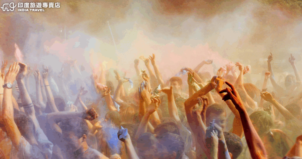這張照片展現印度灑紅節（Holi Festival）現場最熱烈的時刻，數百人同時將彩粉拋向天空，空氣中瀰漫著粉紅、藍、黃、橙等繽紛色彩，營造出夢幻般的節慶氛圍。畫面中群眾高舉雙手，彼此互相灑粉、歡呼慶祝，象徵友誼、喜悅與春天的到來。整體色彩層次豐富，充滿動感與生命力，是體驗印度節慶文化的代表畫面。