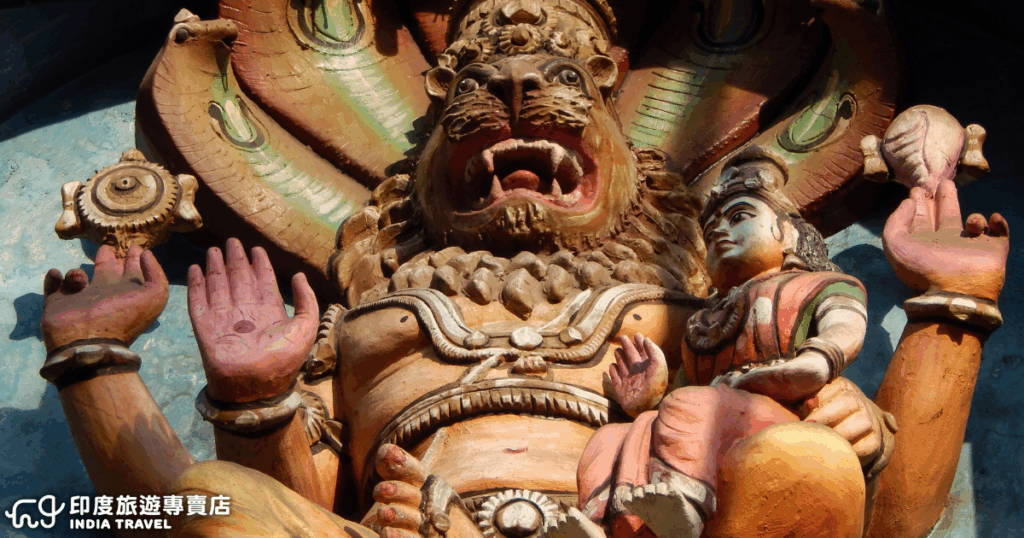這張照片呈現印度教神祇奈拉希瑪(Narasimha)的精緻石雕造像,他是毗濕奴(Vishnu)的化身之一,以半人半獅的形象聞名,象徵正義與力量的守護者。畫面中,奈拉希瑪神神情威嚴,張口怒吼,手持法器與象徵守護的蓮花,旁邊坐著信徒或神祇,展現濃厚的宗教藝術風格。整體色彩飽滿,雕刻細節生動,體現南亞寺廟建築與信仰文化的莊嚴氛圍。